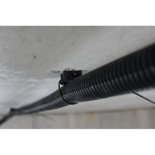Uchwyt TBB szary zamocowany do stropu betonowego z peszlem instalacyjnym