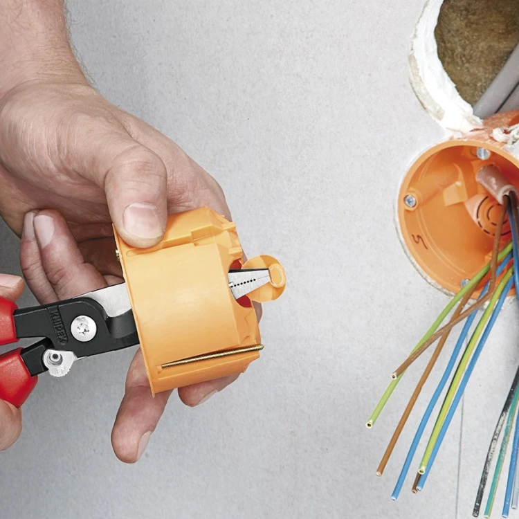Szczypce wielofunkcyjne Knipex 13 92 200 podczas obróbki puszki podtynkowej