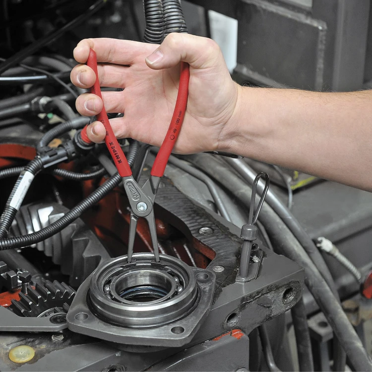 Szczypce Knipex 48 11 J1 podczas montażu wewnętrznego pierścienia osadczego