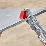 Obcęgi Knipex 91 13 250 ustawione na naciętej płytce ceramicznej
