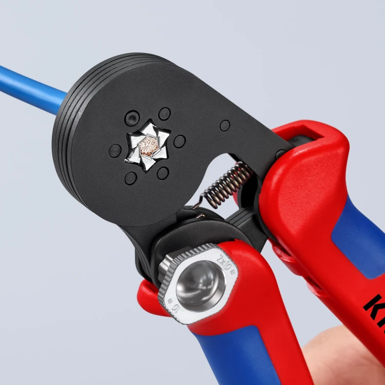 Szczypce Knipex 97 53 14 podczas sześciokątnego zagniatania tulejki na niebieskim przewodzie elektrycznym