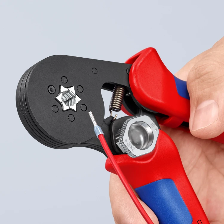 Szczypce Knipex 97 53 14 z widoczną sześciokątną matrycą i zaciśniętą tulejką na czerwonym przewodzie