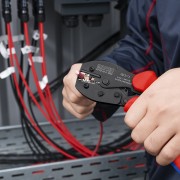 Monter zaciskający przewód fotowoltaiczny szczypcami Knipex 97 52 42 6 podczas prac przy instalacji PV